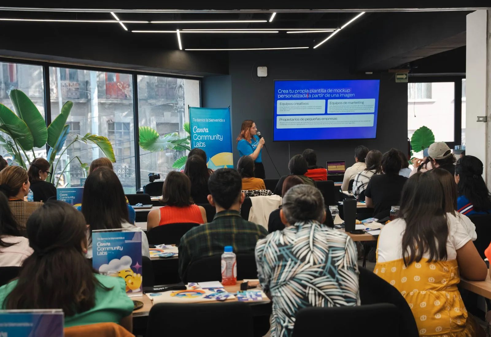Grupo de adultos assiste a uma apresentação em sala de capacitação